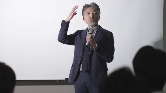 セミナーでプレゼンを行うミドルビジネスマン
