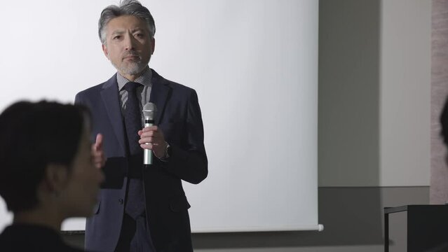 セミナーでプレゼンを行うミドルビジネスマン