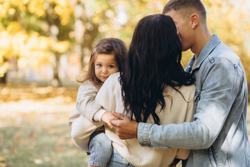 Happy young family spending time together in autumn park