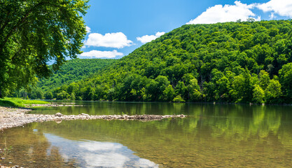 Fototapeta na wymiar The Allegheny River flowing through the river valley in Althom, Pennsylvania, USA on a sunny summer day