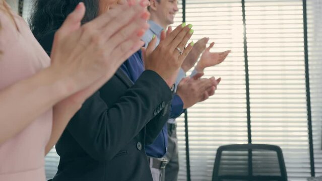 Close up group of businessman and woman clap hands together in office.