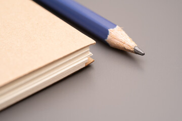 Obraz premium closed blank craft paper cover notebook with pencil. Office and study items close-up.