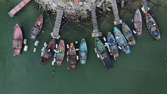 Small fishing boats are lined up behind the rocky shoreline, Aerial view, Eastern of Thailand