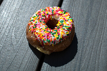 donut with sprinkles on grey wood