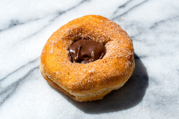 chocolate-filled sugar doughnut on marble 