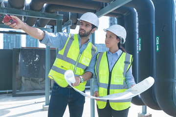 Engineer under checking the industry chilled water fan coil unit air conditioner is water cooling tower air chiller HVAC system of large industrial building to control air system
