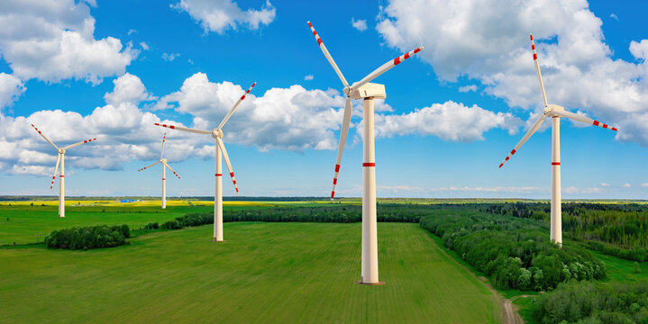 Wind generators. Lots of windmills. Generation of electricity from wind. Summer landscape with windmills. Farm with color turbines. Panoramic shot. Environmentally friendly wind power plant. 3d image.