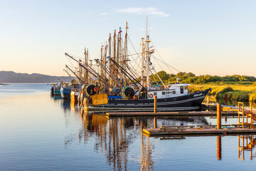 Commercial fishing boats in the harbor during a sunset