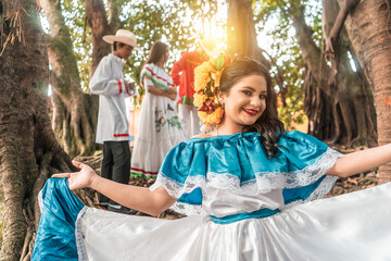 Latin young woman smiling and looking at camera wearing traditional Nicaraguan dress in a forested...