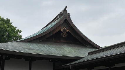 Fototapeta na wymiar Old traditional temple architecture of Japan, rustic “Gegyo” decor and the “Omune” on the top of the roof, cloudy sky year 2022 June 23rd at “Kiyomizu Kannon-do” Tokyo Japan