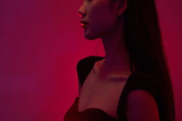 Fashion and beauty concept, Portrait of asian woman in black dress to pose in neon light background