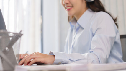 Business concept, Businesswoman in headset to meeting on video conference and taking notes on paper