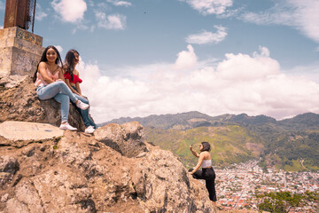 Pretty young women enjoying and taking pictures on the top of the highest mountain in Jinotega...