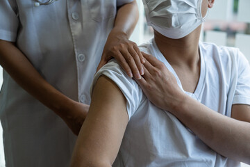 Obraz premium Physician consulting with patient About the problem of shoulder muscle pain, physiotherapy diagnosis concept. with stretching exercises with flexible exercise bands