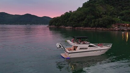 Yacht in Calm sea water during moody sunset, group of People relaxing on board, Aerial drone Orbiting - Powered by Adobe