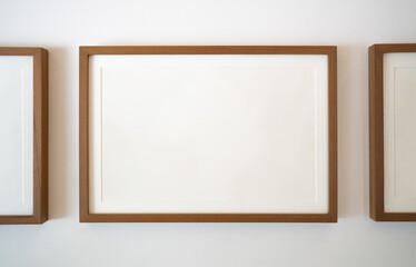 Wooden photo frames on white wall