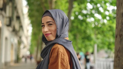 Muslim woman walking and turning to smile to the camera