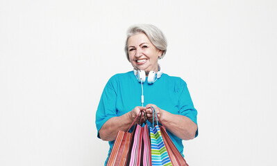 Happy mature woman with shopping bags isolated on white background