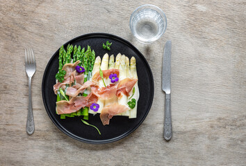 White and green asparagus with prosciutto ham and sauce. Great seasonal food, easy cooking meal for keto diet dinner or lunch.