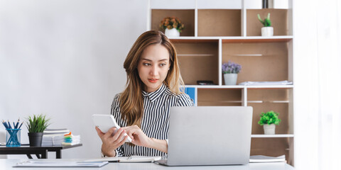Business asian woman using calculator for do math finance on wooden desk in office, tax, accounting, financial concept.