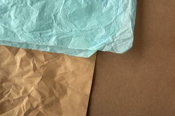 Top down view or flat lay brown and light blue creased wrap paper on recycled cardboard box paper...