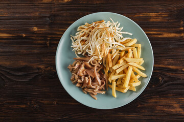 Appetizer for beer. Assorted smoked meat, salted cheese and French fries in a plate on a wooden table top view. Horizontal orientation, flatlay, no people, copy space