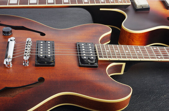 Two jazz electric guitars on a dark background. Close up.