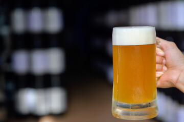 Male craft brewer holding beer mug at brewery Small Business and the Beer Industry golden yellow beer mug in warehouse