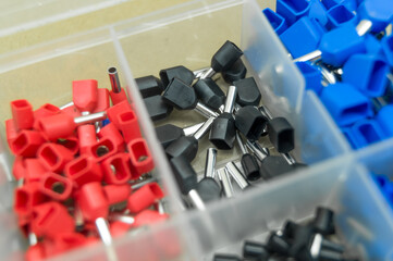 A set of colored crimp terminals for electrical wires. Crimping sleeves of different sizes. Plastic...