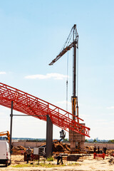 Installation of metal trusses and frame during the construction of an industrial building or factory. The work of installers during the installation of the roof. Construction of a large frame shop.