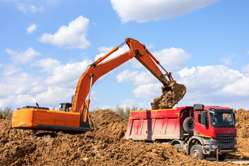 Excavator loading dump truck on the construction site