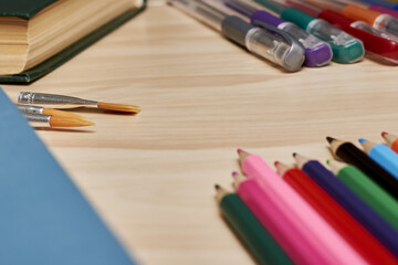 books pencils fountain pens and brushes for drawing on the table concept education school