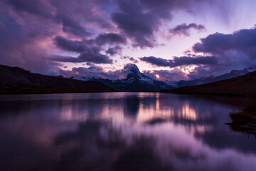 Fototapeta na wymiar Beautiful sunset colors and cloudscape in the Swiss Alps in summer, with Matterhorn reflection in a lake