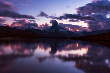 Fototapeta na wymiar Beautiful sunset colors and cloudscape in the Swiss Alps in summer, with Matterhorn reflection in a lake