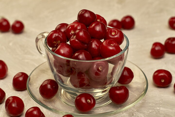 red ripe cherries in a teacup on the table