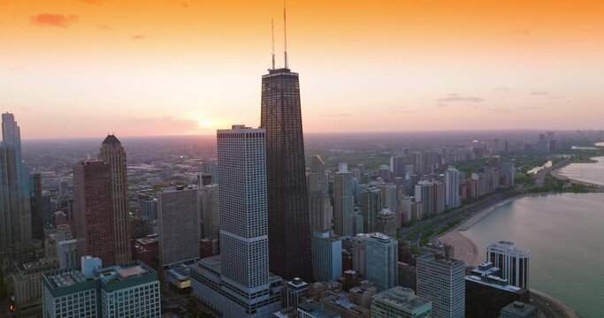 Flight over the waterfront built up with wonderful architecture. Chicago skyscrapers at the backdrop of orange sky.