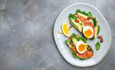 toast with avocadoo, salmon and spinach, nuts, sunflower seeds. Healthy, clean eating. Vegan or gluten free diet. top view, copy space