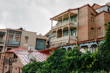 Facade of traditional carved balconies and colorful wooden houses in the Old Town of Tbilisi, Georgia.