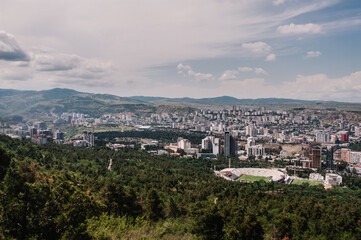 Fototapeta na wymiar View of the city of Tbilisi in the capital of Georgia. All main landmarks on one shot: church, new and old houses, tower, city, town, mountains, park, stadium and streets.