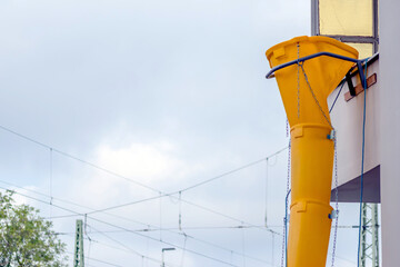 Yellow rubble chute or rubble slide at facade of old white house helps with renovation and...