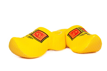 Pair of traditional Dutch yellow wooden shoes over white background. Popular souvenirs. Traditions...