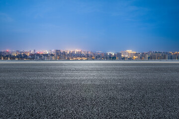 Asphalt road and modern city skyline with building scenery at night. high angle view.