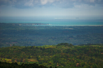 panoramic view of indonesian morning on the mountain with green tropical forest and beautiful blue sea