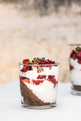 Breakfast layered parfait dessert with yogurt, sponge biscuit and fresh strawberry, white background copy space