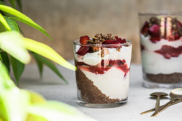 Breakfast layered parfait dessert with yogurt, sponge biscuit and fresh strawberry, white background copy space