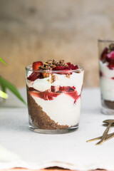 Breakfast layered parfait dessert with yogurt, sponge biscuit and fresh strawberry, white background copy space