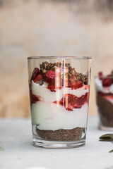 Breakfast layered parfait dessert with yogurt, sponge biscuit and fresh strawberry, white background copy space