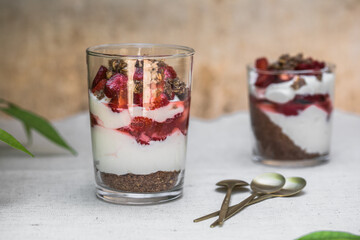 Breakfast layered parfait dessert with yogurt, sponge biscuit and fresh strawberry, white background copy space