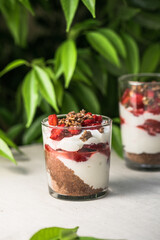 Breakfast layered parfait dessert with yogurt, sponge biscuit and fresh strawberry, white background copy space