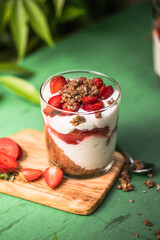 Breakfast layered parfait dessert with yogurt, sponge biscuit and fresh strawberry, white background copy space